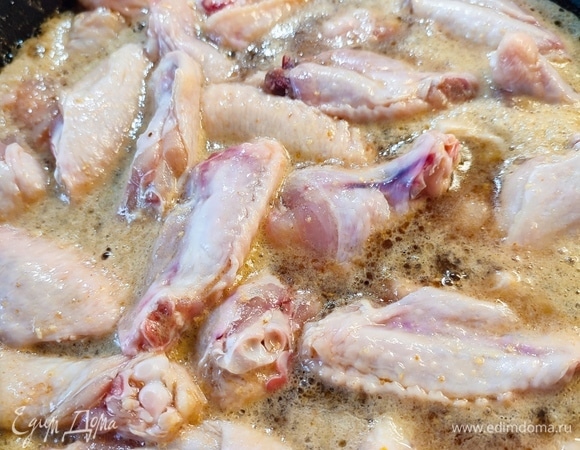 В сковороду добавить крылышки. Накрыть крышкой и оставить кипеть на 10 минут.
