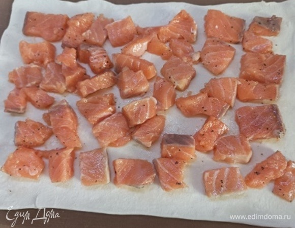 Тесто раскатать в два пласта. На один выложить кусочки рыбы, оставляя края свободными.