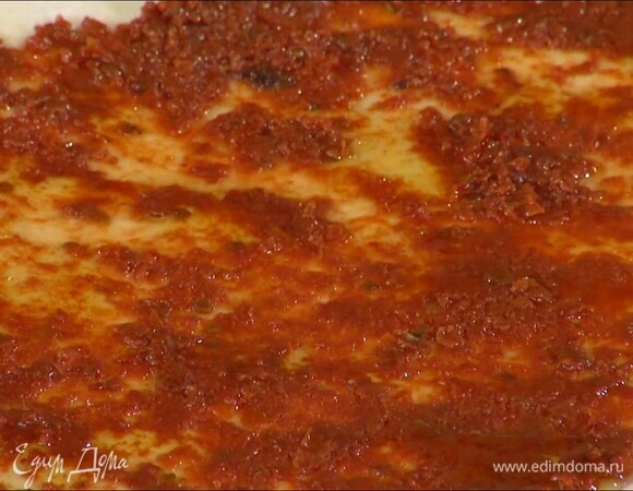 Противень выстелить бумагой для выпечки, выложить тесто и равномерно распределить взбитые помидоры по половине пласта, отступая от краев, затем немного сбрызнуть все оливковым маслом.