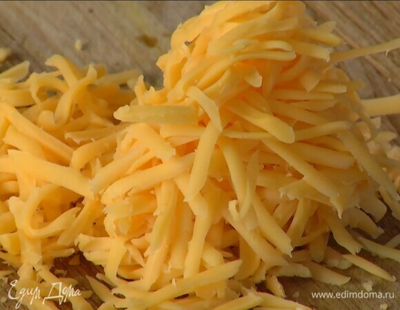 Чеддер натереть на крупной терке и посыпать томатную массу.