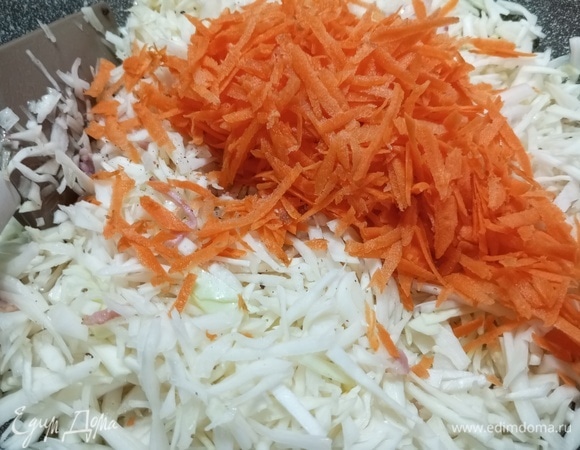 Добавить нашинкованную капусту и тертую морковь. Жарить, помешивая, на сильном огне 10–15 минут.
