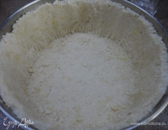 Форму смазать маслом (диаметр — 20 см) и высыпать крошку, сформировать дно и бока, но при этом сильно не утрамбовывать.