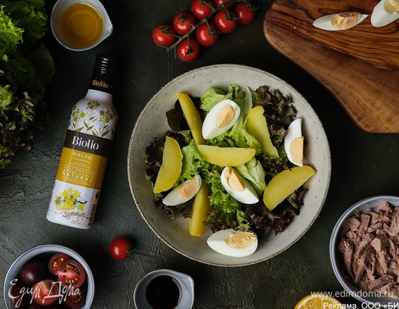 Выложите в салатник листья салата, сверху — дольки картофеля и яйца.