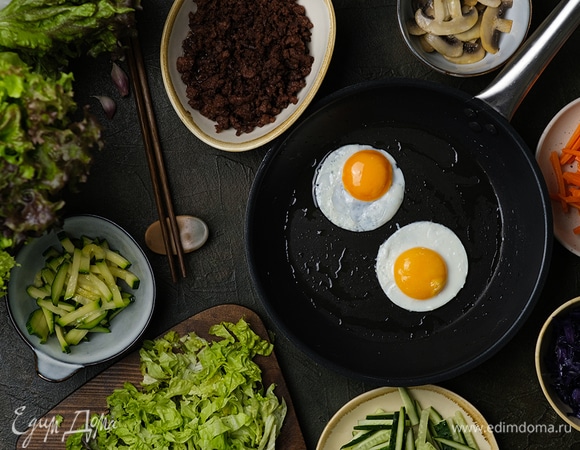 В сковороде разогрейте 2 ст. л. растительного масла, выложите соломку из кабачка, добавьте щепотку соли и томите на среднем огне в течение 2–3 минут. Переложите в чистую посуду.<br />
<br />
Аналогично пожарьте морковь, капусту и грибы. <span>Обжарьте фарш до готовности, затем добавьте чеснок и томите около 1–2 минуты. </span><span>Влейте в фарш соевый соус, тушите 2–3 минуты и переложите заготовку в чистую посуду. </span><span>Приготовьте 4 глазуньи.</span>