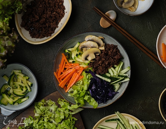 Сверху на рисовую подушку выложите припущенные овощи, грибы, фарш, а также нарезку из свежего огурца и салат.