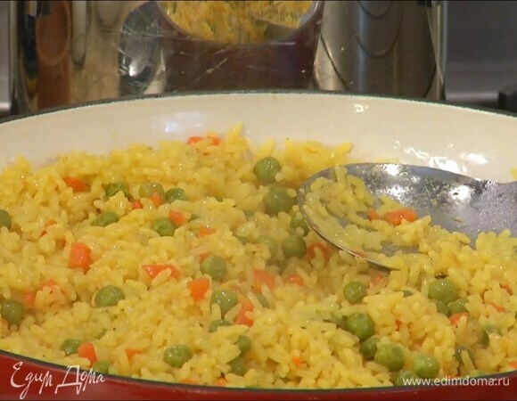 Рис всыпать в сотейник с овощами, все перемешать, залить горячим бульоном, накрыть крышкой и томить до готовности.