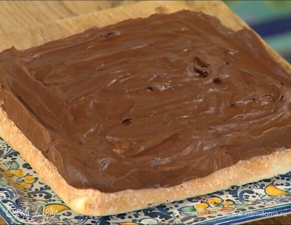 Подрумяненный корж вынуть из духовки и придавить лопаткой, чтобы он стал плотнее, сверху равномерно разложить шоколадно-сливочный крем и отправить в холодильник на 3 часа.