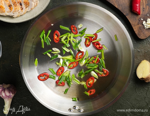 В глубокой сковороде разогрейте рисовое масло Biolio и обжарьте на нем перец чили и зеленый лук.