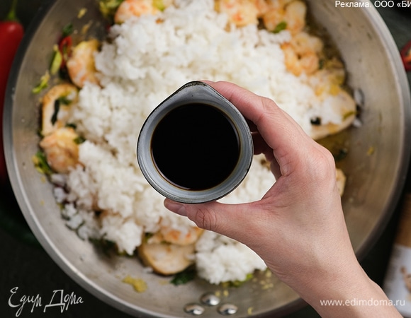 Положите рис, перемешайте, влейте соевый соус и прогрейте все вместе в течение 2–3 минут.