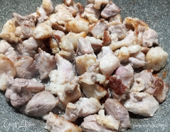 В разогретую сковороду выложить нарезанную кусочками свинину. Обжарить до румяного цвета. Посолить, добавить перец.