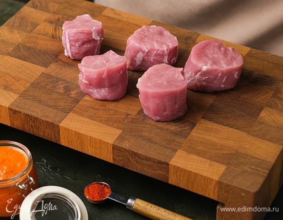 Свиную вырезку очистите от пленок и нарежьте на кусочки толщиной 5 см, переверните срезом вверх. Мелкие хвостики можно собрать вместе и скрепить кольцом из фольги, чтобы по размеру они были похожи на обычные медальоны.