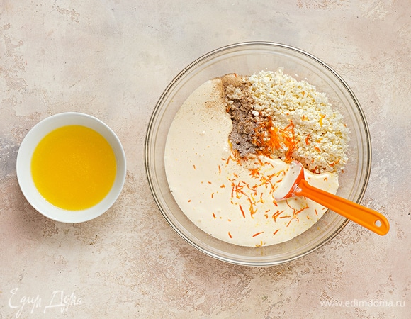 Добавьте к яичной смеси творог, сливочное масло, ванильный сахар и цедру апельсина. Перемешайте до однородности.