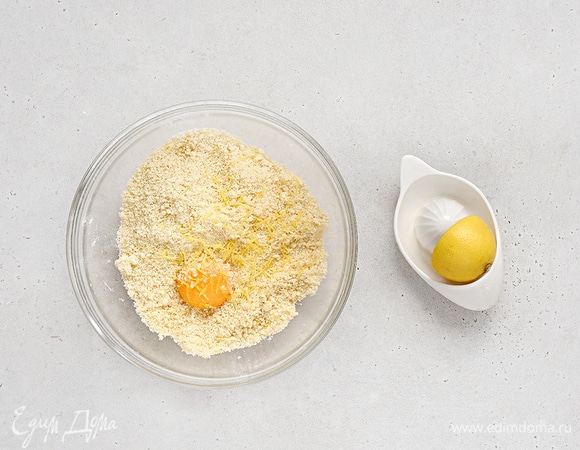 Добавьте желток, сок и цедру лимона, еще раз хорошо перемешайте, пока тесто не соберется в шар.