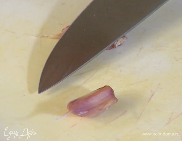 Зубчики чеснока, не очищая, раздавить плоской стороной ножа.