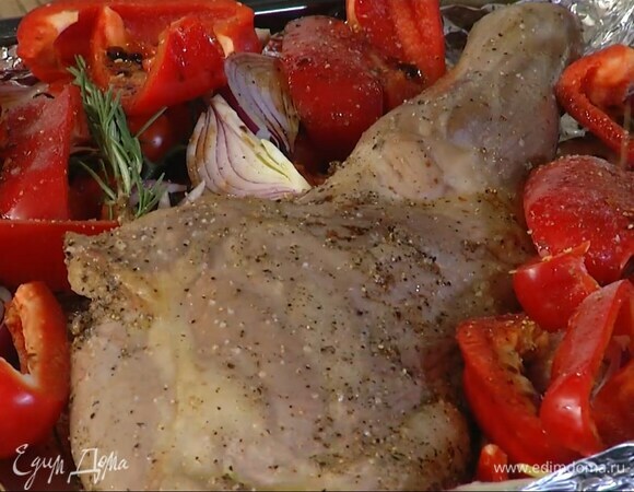 Вынуть противень из духовки, выложить к мясу нарезанные овощи и помидоры черри, полить все оставшимся оливковым маслом и бальзамическим уксусом, добавить половину веточек розмарина, посыпать солью, черным перцем и чили.