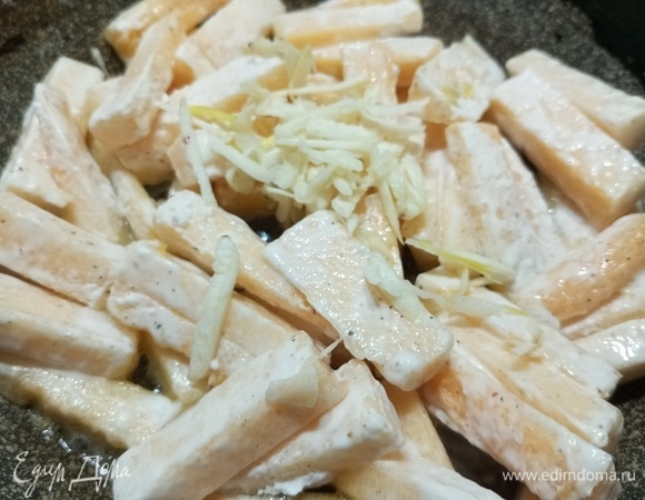 Выложить в разогретую со сливочным маслом сковороду. Посыпать натертым зубчиком чеснока.