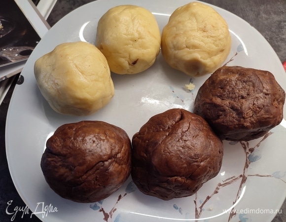 Для теста смешать сметану, сахар и разрыхлитель. Сливочное масло растопить, остудить и добавить к сметанной массе. Перемешать. Постепенно всыпать муку с солью. Замесить мягкое тесто. Разделить тесто на две части. В одну добавить какао. Каждую часть разделить на три шарика, накрыть пленкой и поставить в холодильник на 1 час.