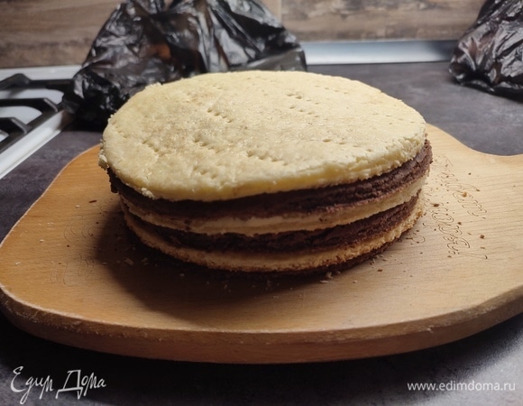 Охлажденное тесто раскатать, наколоть вилкой. Выпекать 5–7 минут при температуре 200°C. Еще горячим корж обрезать по форме. Получается 6 коржей.