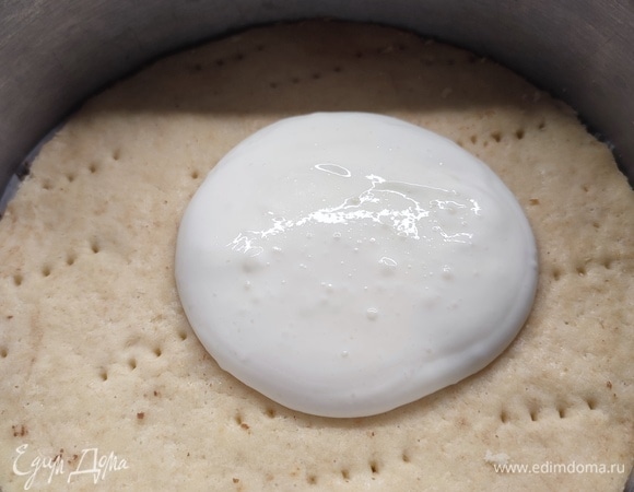 Первый корж положить в сборочное кольцо. Выложить на него крем. Он будет жидким, но потом после холодильника загустеет. Коржи надо чередовать по цвету.