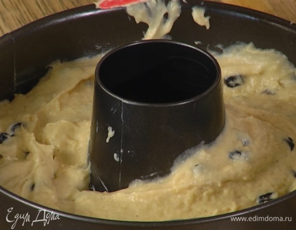 Круглую разъемную форму для выпечки с отверстием посередине смазать оставшимся сливочным маслом и равномерно выложить тесто.