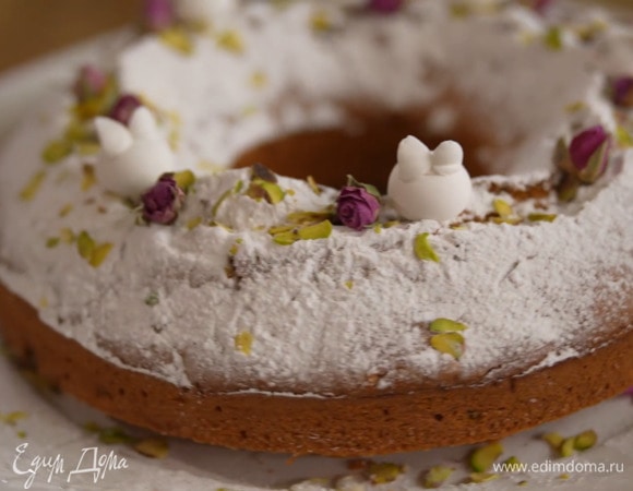 Теплый кекс посыпать сахарной пудрой, украсить фисташками и цветами.