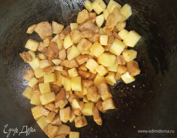 Добавляем картофель (без воды). Обжариваем еще минуту. Добавляем имбирь, чеснок и лук (репчатый и белую часть зеленого). Обжариваем 1 минуту.