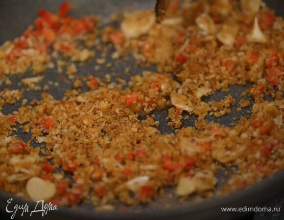 Приготовить сухарную посыпку: чеснок почистить и нарезать тонкими пластинками, чили, удалив семена, мелко порубить, выложить все в сковороду с разогретым оливковым маслом и перемешать, затем всыпать сухари, еще раз перемешать и немного прогреть.