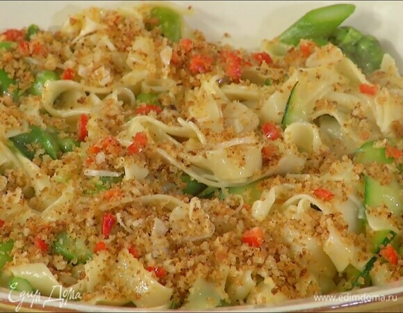 Выложить к цукини со спаржей готовые макароны, влить немного сохраненной воды и перемешать, затем переложить все в большое блюдо и посыпать сухарной крошкой.