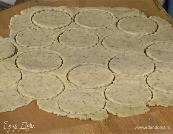 Раскатать тесто в пласт между двумя листами бумаги для выпечки и вырезать равное количество кружков — половину поменьше диаметром, половину побольше.
