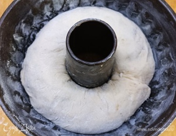 Круглую кексовую форму смазать тонким слоем сливочного масла и посыпать мукой. Подошедшее тесто выложить на посыпанную мукой рабочую поверхность и тонко раскатать, примерно 30 х 50 см. Распределить начинку по поверхности раскатанного теста, отступая 1–1,5 см от краев, и разровнять лопаткой. Скатать тесто в рулет и выложить в подготовленную форму, скрепить края рулета вместе. Оставить на 1,5 часа подходить, накрыв форму с тестом слегка влажным полотенцем.