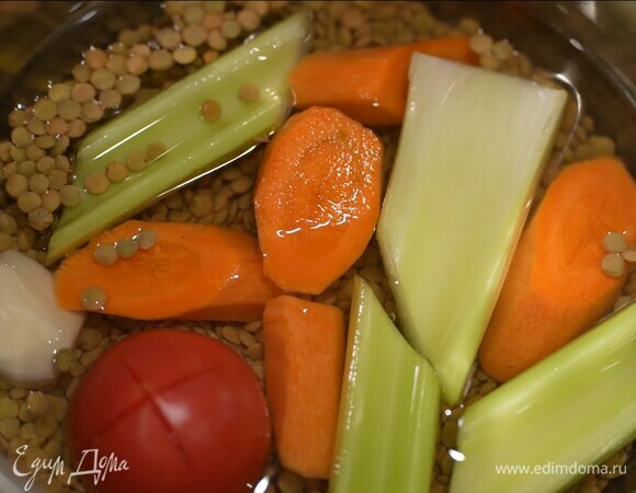 Чечевицу всыпать в кастрюлю, залить водой согласно инструкции на упаковке и, добавив нарезанную морковь, сельдерей, помидор и чеснок, варить до готовности, затем овощи удалить.