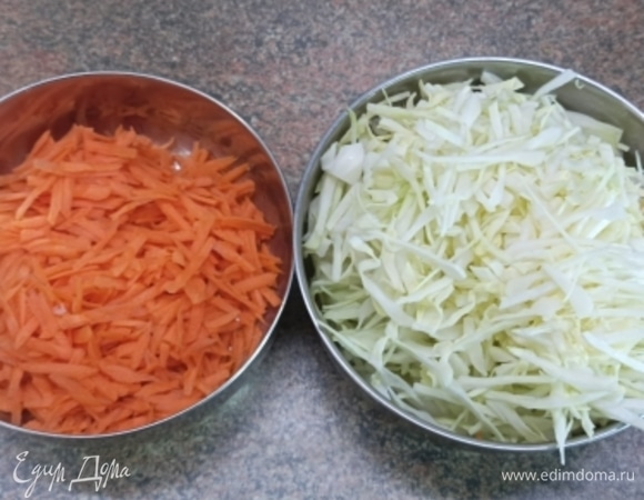 Капусту мелко шинкуем, морковь натираем на терке. Лук нарезаем полукольцами и обжариваем в растительном масле до золотистого цвета. Добавляем на сковороду к луку овощи и обжариваем, пока капуста не станет мягкой. Солим и перчим по вкусу. Убираем с плиты. Включаем духовку для разогрева на 200°C.