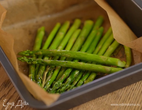Спаржу, отломив грубые черенки, выложить в небольшой противень, выстеленный бумагой для выпечки, посолить, поперчить, сбрызнуть оливковым маслом и соком лайма, затем запечь в разогретой духовке и разрезать пополам.