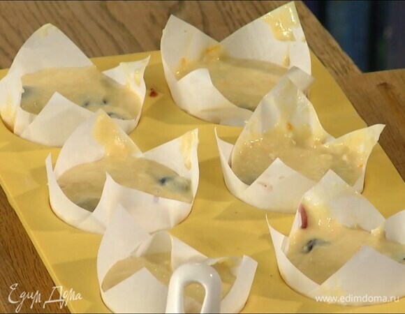 В формочки для кексов поместить бумажные вкладыши, выложить в них немного теста, затем по 1 ст. ложке черничного джема, а сверху снова тесто.