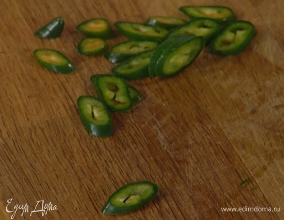 Перец чили, удалив семена, нарезать тонкими колечками.