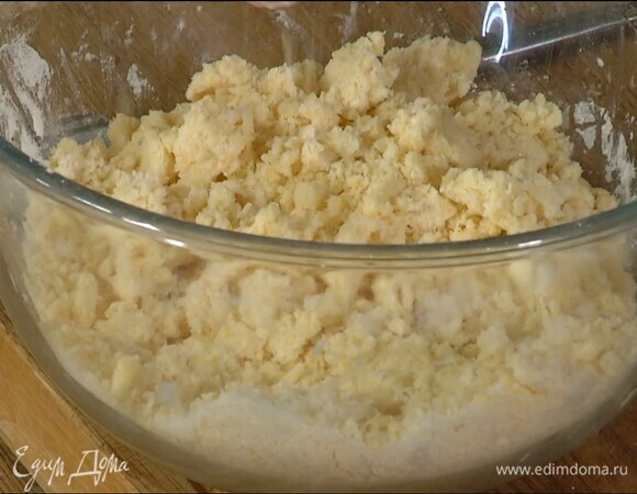 Добавить желтки, ванильный экстракт, уксус и руками растереть все в рассыпчатую крошку.