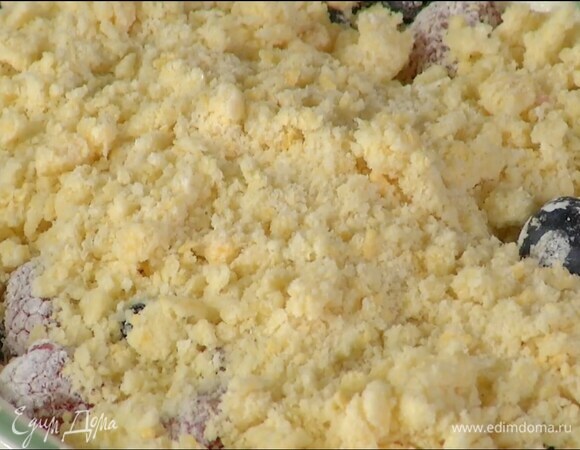 Смазать жаропрочную керамическую форму оставшимся сливочным маслом, выложить в нее ягоды и засыпать сверху мучной крошкой.