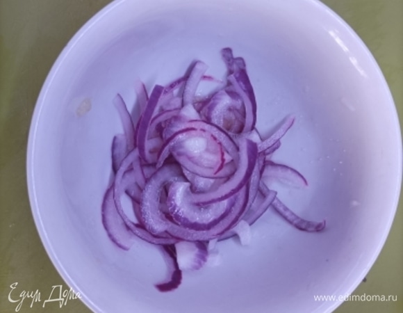 Красный лук нарезать полукольцами и ошпарить кипятком. Затем сбрызнуть лимонным соком, посолить и оставить на 5 минут мариноваться.