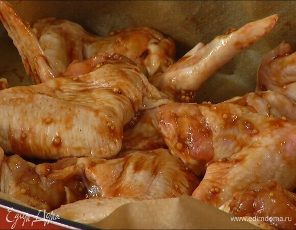 Небольшую глубокую форму выстелить бумагой для выпечки, выложить крылья вместе с соусом.