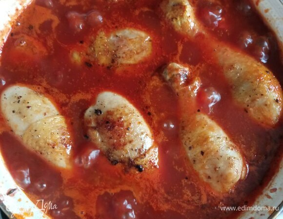 В сковороде обжариваем томатную пасту 3 минуты, добавляем аджику и пропущенный через пресс чеснок. Добавляем консервированные помидоры. Если у вас в банке они целые, предварительно нарезаем. Доводим до кипения, солим, перчим, добавляем сахар по вкусу. У меня примерно 1 чайная ложка. Можно меньше. Заливаем красным вином. Добавляем тимьян и прогреваем минут 5, чтобы сахар растворился, а алкоголь выпарился. Заливаем соусом голени и тушим на среднем огне минут 40.