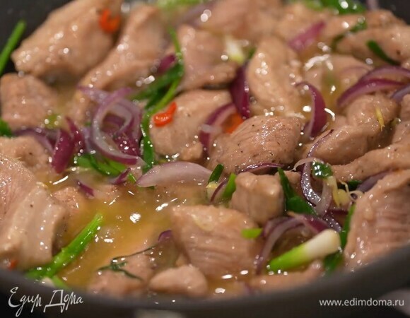 Зеленый лук крупно порезать наискосок, добавить в вок и все перемешать, затем выложить обжаренную индейку, влить рисовое вино и, помешивая, обжарить.