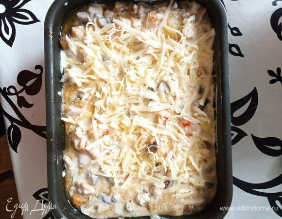 Перекладываем курицу с грибами в форму и заливаем смесью. Перемешиваем. Сыр трем на крупной терке и посыпаем сверху.