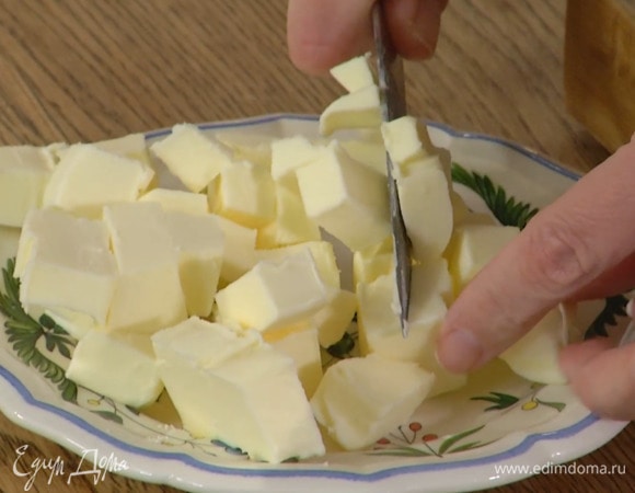 Предварительно охлажденное сливочное масло нарезать кубиками.