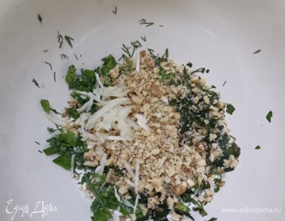 Зелень укропа и перья лука порубить и растолочь с солью. Зелень петрушки (листья) нарезать. Орехи порубить ножом, чеснок пропустить через пресс или натереть на мелкой терке.