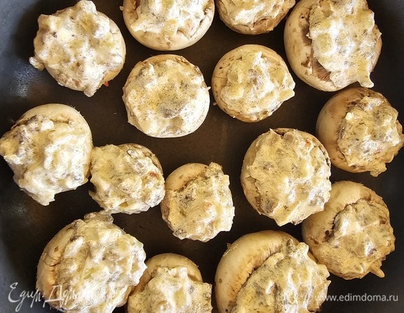 Нафаршировать готовой начинкой шляпки. Поставить их запекаться в духовку при 200°C минут на 15–20. Или можно поставить в сковороде на плиту минут на 15, накрыв крышкой. Добавлять масло не надо, шампиньоны выделят достаточно влаги.