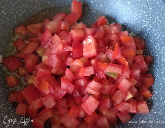 К чесноку добавляем нарезанный томат, увеличиваем огонь, готовим 5 минут.