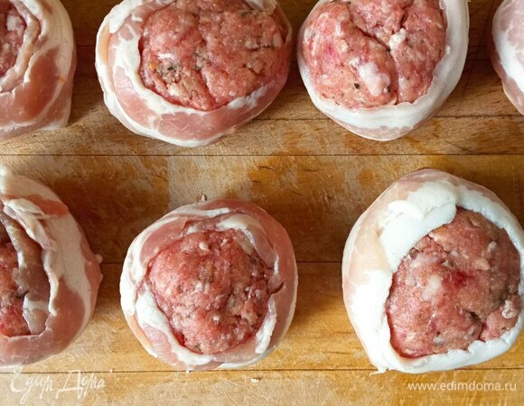 Хлеб замачиваем в молоке и вводим его в фарш. Добавляем яйцо. Тщательно перемешиваем, солим, перчим и добавляем тимьян. Формируем круглые биточки, каждый оборачиваем лентой бекона. При необходимости бекон можно закрепить зубочисткой. У меня и так хорошо держался.