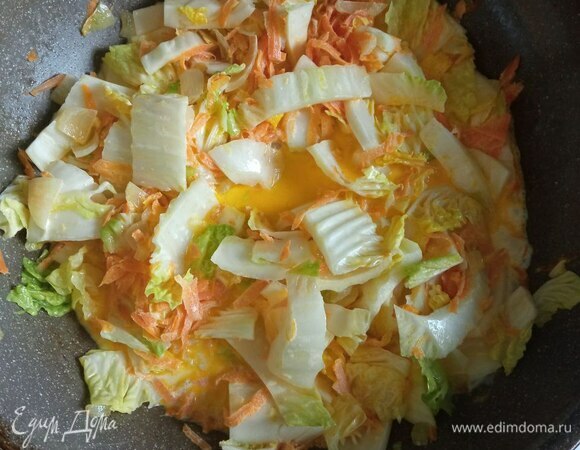 Добавляем нашинкованную пекинскую капусту. Солим и перчим по вкусу, обжариваем пару минут.