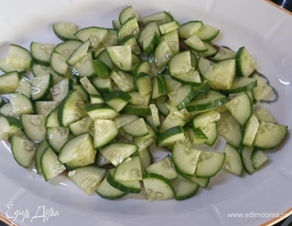 Огурец разрезать вдоль на четыре части, а затем на кусочки. Выложить в блюдо, сбрызнуть свежевыжатым соком лимона и оливковым маслом. Оливки нарезать кружочками и выложить сверху.