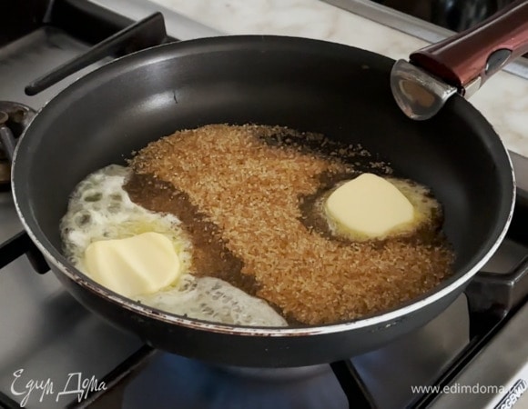 В сковороду со съемной ручкой всыпать 2 ст. ложки сахара, добавить сливочное масло и растопить все на медленном огне в карамель.